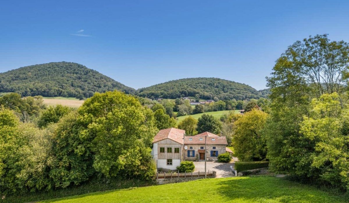 Stone farmhouse with barn and mountain views